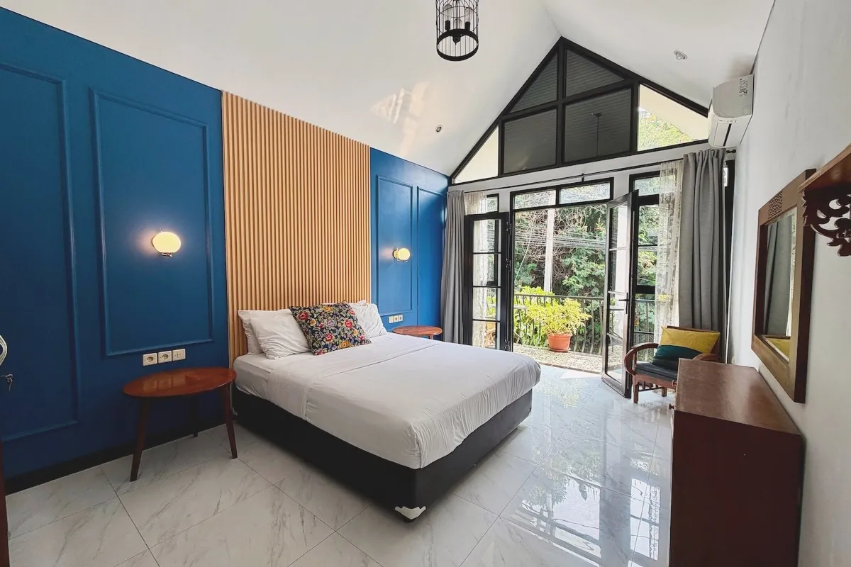 Mezzanine bedroom with queen bed framed by mountain and city views through pitched picture windows
